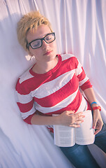 Image showing woman reading a book while relaxing on hammock