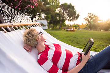 Image showing woman using a tablet computer while relaxing on hammock