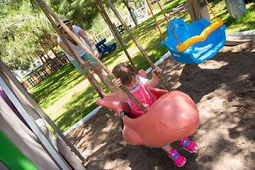 Image showing mother and daughter swinging in the park