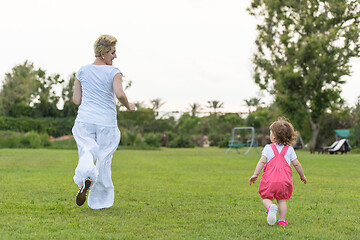 Image showing mother and little daughter playing at backyard