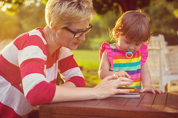 Image showing mom and her little daughter using tablet computer