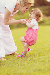 Image showing mother and little daughter playing at backyard