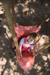 Image showing little girl swinging  on a playground