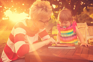 Image showing mom and her little daughter using tablet computer