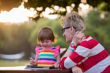 Image showing mom and her little daughter using tablet computer