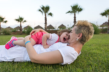 Image showing mother and little daughter playing at backyard