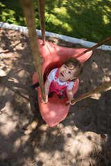 Image showing little girl swinging  on a playground