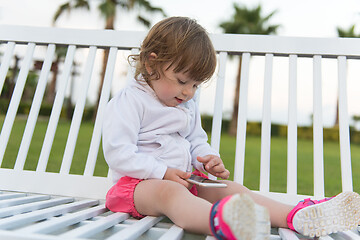 Image showing little girl playing with mobile phone