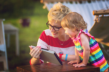 Image showing mom and her little daughter using tablet computer