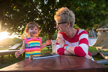 Image showing mom and her little daughter using tablet computer