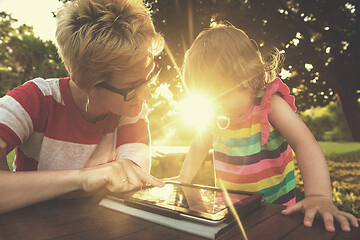 Image showing mom and her little daughter using tablet computer