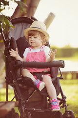 Image showing baby girl sitting in the baby stroller