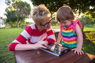 Image showing mom and her little daughter using tablet computer