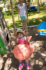 Image showing mother and daughter swinging in the park