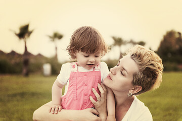 Image showing mother and little daughter playing at backyard