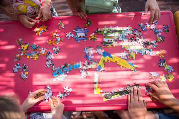 Image showing top view of kids hands playing with puzzles