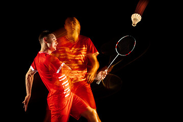 Image showing Young man playing badminton isolated on black studio background