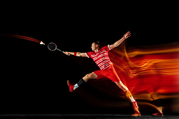 Image showing Young man playing badminton isolated on black studio background