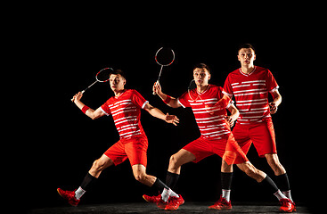 Image showing Young man playing badminton isolated on black studio background