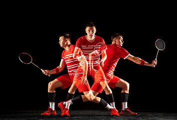 Image showing Young man playing badminton isolated on black studio background