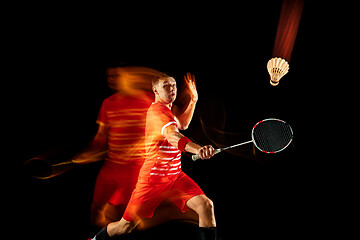 Image showing Young man playing badminton isolated on black studio background