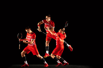 Image showing Young man playing badminton isolated on black studio background