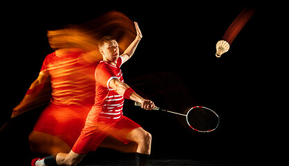 Image showing Young man playing badminton isolated on black studio background