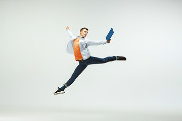 Image showing Man working at office and jumping isolated on studio background