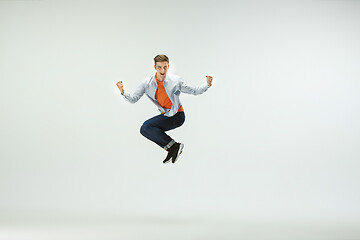 Image showing Man working at office and jumping isolated on studio background