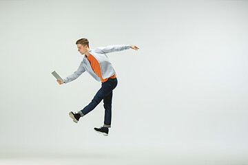 Image showing Man working at office and jumping isolated on studio background