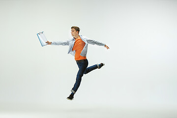 Image showing Man working at office and jumping isolated on studio background
