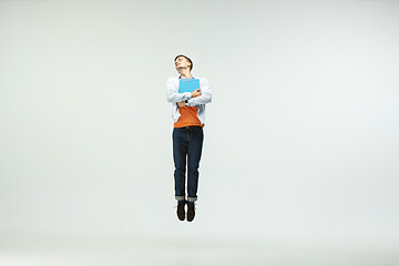 Image showing Man working at office and jumping isolated on studio background
