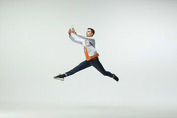 Image showing Man working at office and jumping isolated on studio background