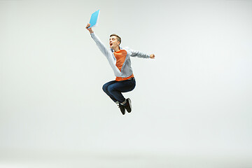 Image showing Man working at office and jumping isolated on studio background