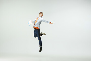 Image showing Man working at office and jumping isolated on studio background