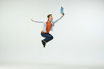 Image showing Man working at office and jumping isolated on studio background