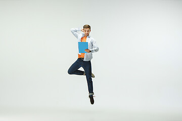 Image showing Man working at office and jumping isolated on studio background