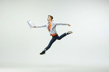 Image showing Man working at office and jumping isolated on studio background