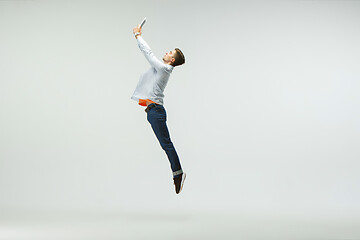 Image showing Man working at office and jumping isolated on studio background