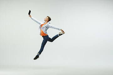 Image showing Man working at office and jumping isolated on studio background