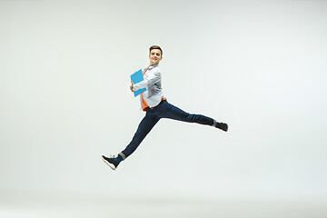 Image showing Man working at office and jumping isolated on studio background