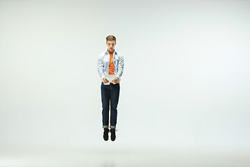 Image showing Man working at office and jumping isolated on studio background