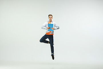 Image showing Man working at office and jumping isolated on studio background