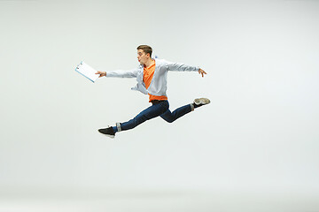 Image showing Man working at office and jumping isolated on studio background