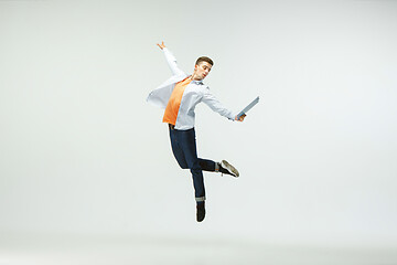 Image showing Man working at office and jumping isolated on studio background