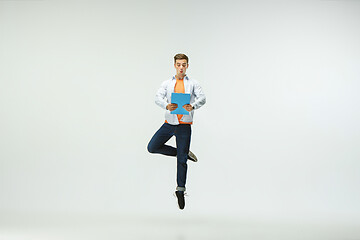 Image showing Man working at office and jumping isolated on studio background