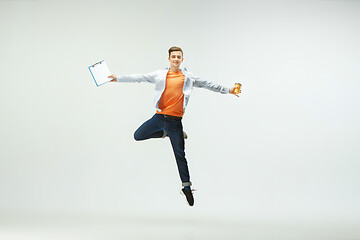 Image showing Man working at office and jumping isolated on studio background