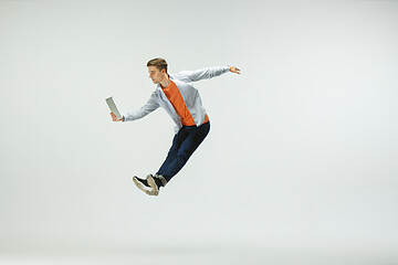 Image showing Man working at office and jumping isolated on studio background