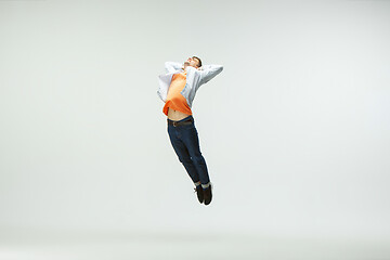 Image showing Man working at office and jumping isolated on studio background