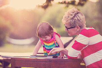 Image showing mom and her little daughter using tablet computer